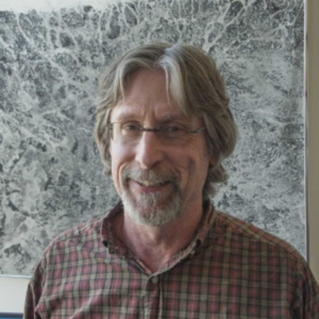 McGlynn in front of a gray background